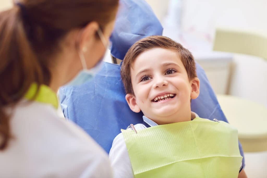 A Child With A Dentist In A Dental Office.